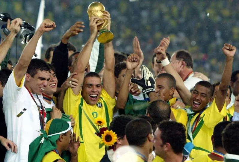 Jogador Ronaldo Fenomeno segurando a taça de campeão da copa do mundo de 2002.